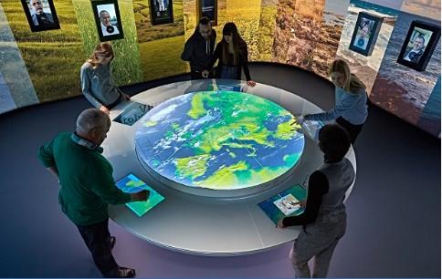 Lidé v interaktivním prostoru prohlížející si na interaktivní mapě Evropu
